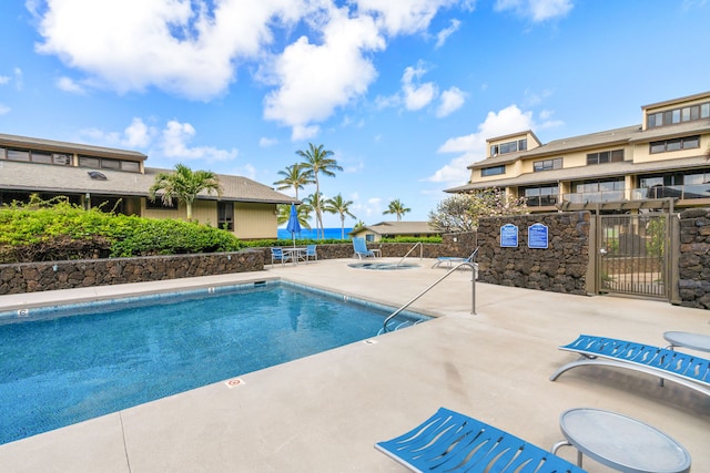 view of swimming pool featuring a water view and a patio area