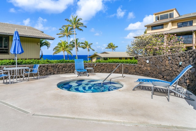 view of swimming pool featuring a patio and a water view