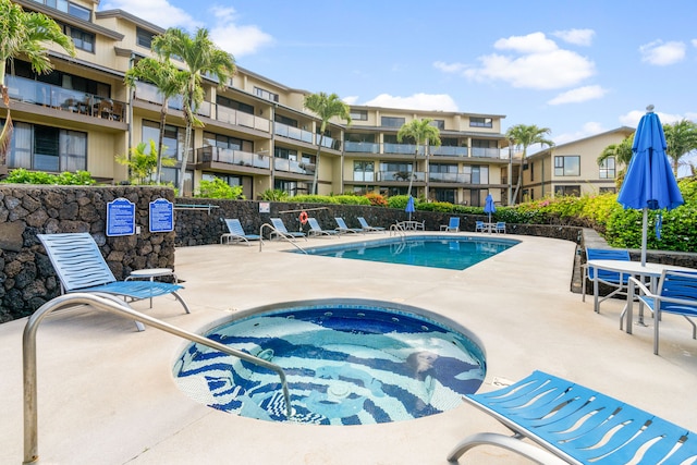 view of pool with a hot tub and a patio area