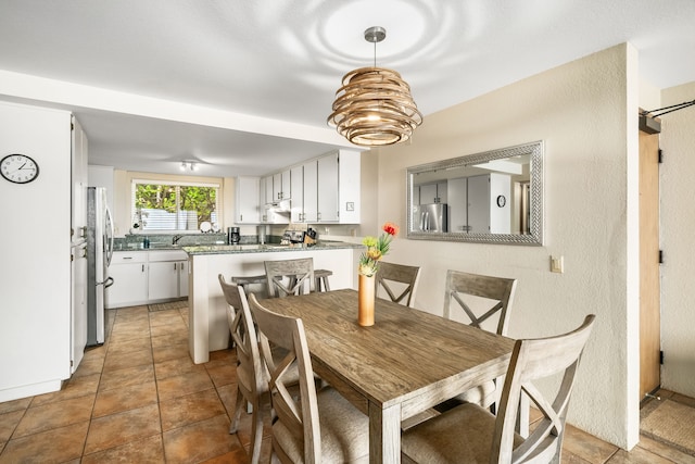 tiled dining room featuring sink