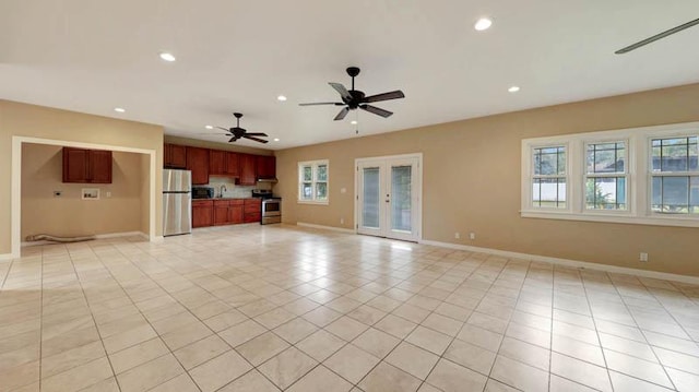 unfurnished living room featuring french doors, light tile patterned floors, ceiling fan, and a healthy amount of sunlight