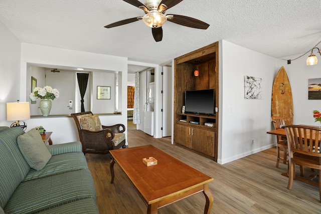 living room featuring ceiling fan, wood-type flooring, and a textured ceiling