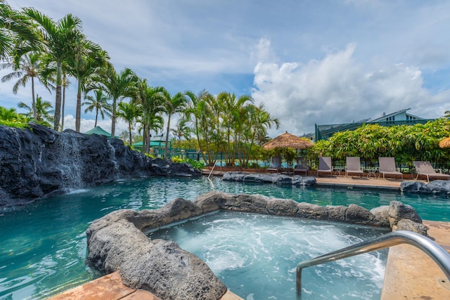 view of pool featuring an in ground hot tub and pool water feature