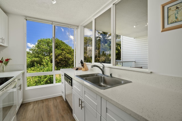 kitchen with dishwasher, sink, dark hardwood / wood-style flooring, white cabinets, and white stove