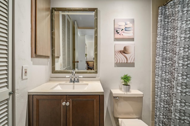 bathroom with vanity, curtained shower, and toilet