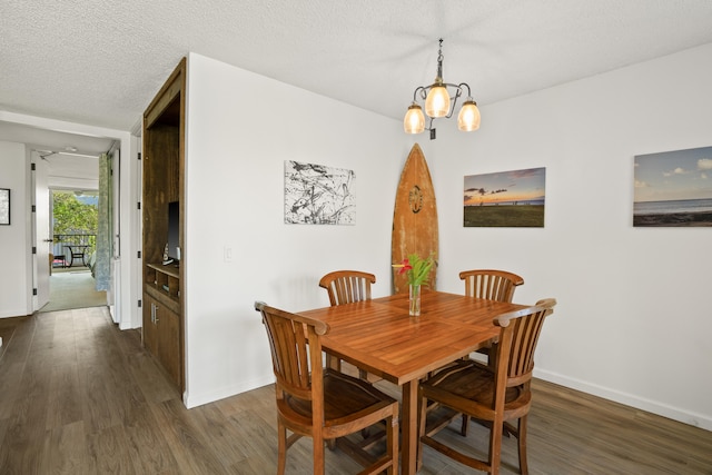 dining space featuring dark hardwood / wood-style floors, a textured ceiling, and a chandelier