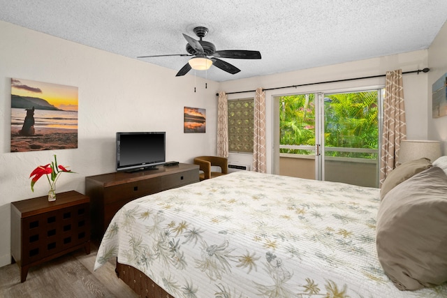 bedroom featuring ceiling fan, access to exterior, light wood-type flooring, and a textured ceiling