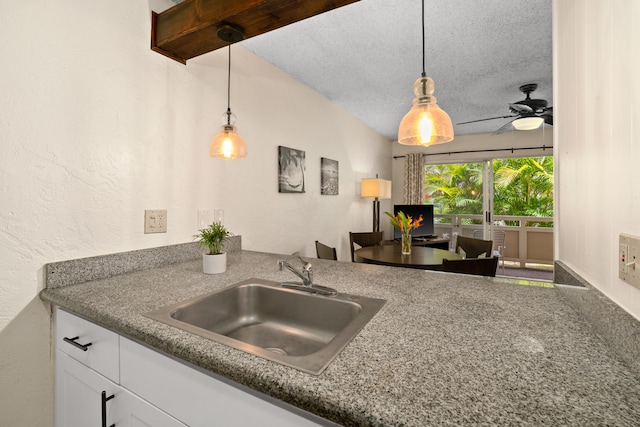 kitchen with white cabinets, ceiling fan, hanging light fixtures, and sink