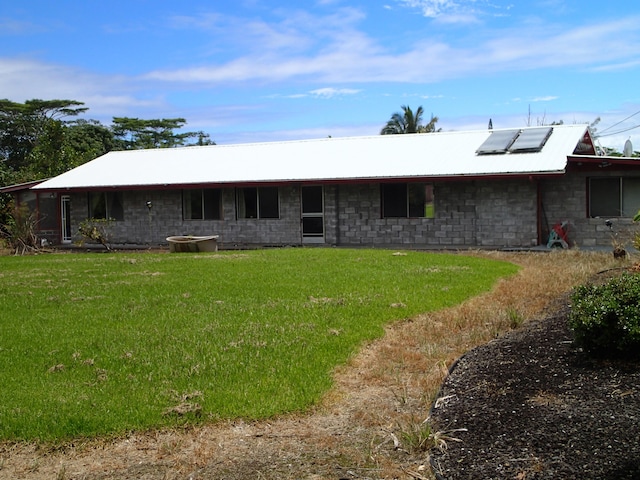 back of house featuring solar panels and a yard