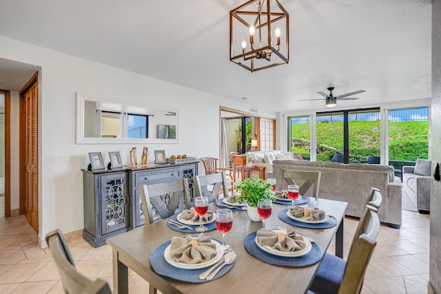 tiled dining space featuring ceiling fan with notable chandelier