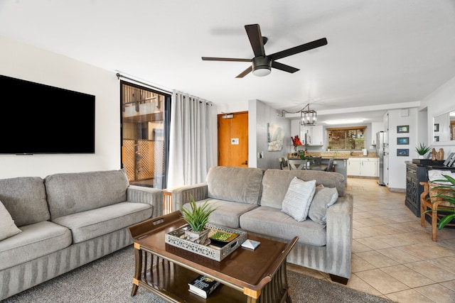 living room featuring ceiling fan with notable chandelier and light tile patterned floors