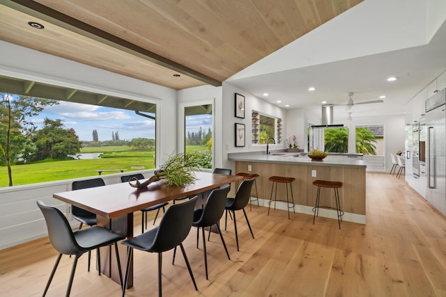 dining space with lofted ceiling with beams, sink, wood ceiling, and light hardwood / wood-style flooring