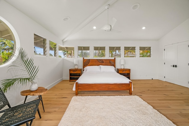 bedroom with lofted ceiling with beams and light wood-type flooring