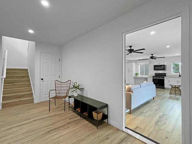 corridor featuring a wall mounted air conditioner and light wood-type flooring