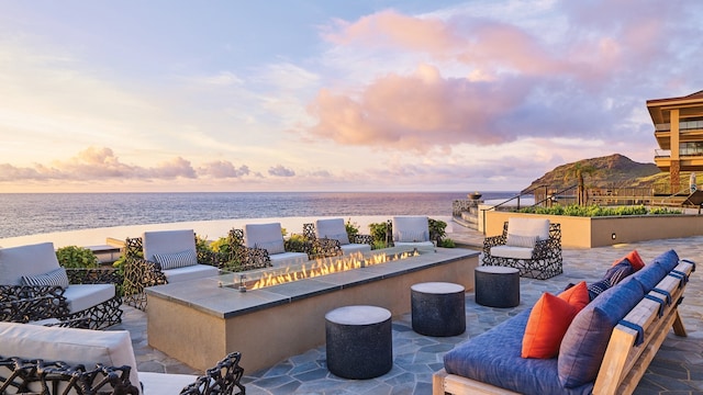 patio terrace at dusk featuring outdoor lounge area and a water view