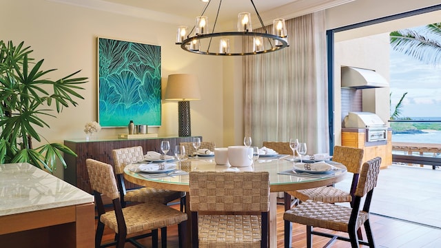 dining area with a chandelier, wood-type flooring, crown molding, and a water view