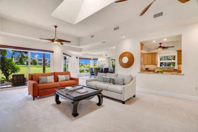 carpeted living room featuring ceiling fan and a wealth of natural light