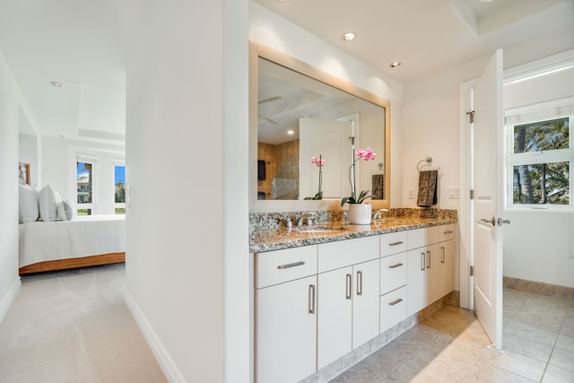 bathroom with tile patterned flooring, vanity, and a raised ceiling