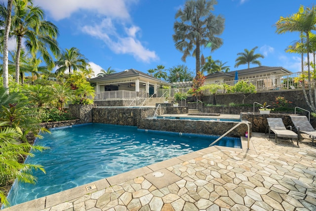 view of pool featuring pool water feature, a patio, and a jacuzzi