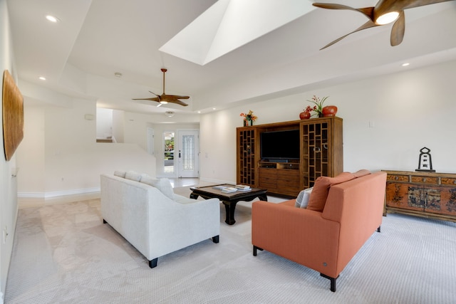 carpeted living room featuring ceiling fan, a raised ceiling, and french doors