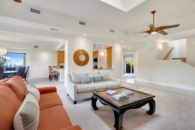 living room featuring plenty of natural light, ceiling fan, and light carpet