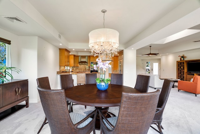 dining room featuring light carpet and ceiling fan with notable chandelier