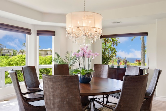 carpeted dining space featuring a chandelier and plenty of natural light