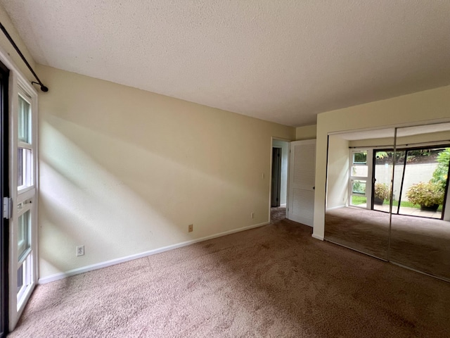 spare room featuring a textured ceiling and carpet floors