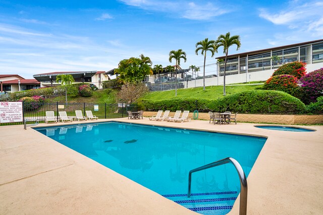 view of swimming pool featuring a community hot tub and a patio