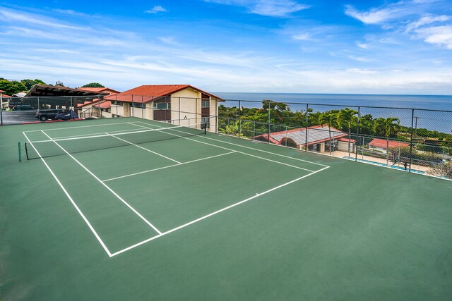 view of tennis court with a water view