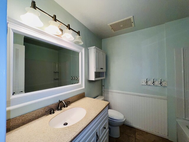 bathroom with tile patterned floors, a tub, vanity, and toilet