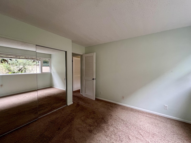 unfurnished bedroom with a closet, carpet, and a textured ceiling