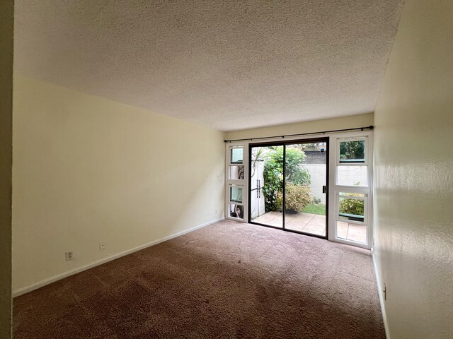 carpeted spare room with a textured ceiling