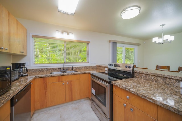 kitchen featuring appliances with stainless steel finishes, a notable chandelier, stone countertops, hanging light fixtures, and sink