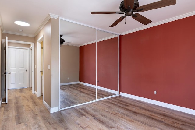 unfurnished bedroom with a closet, light hardwood / wood-style flooring, ceiling fan, and ornamental molding