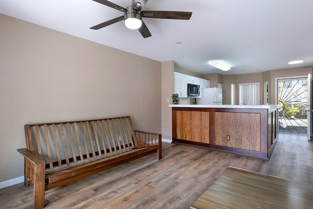 kitchen featuring ceiling fan, white fridge, wood-type flooring, and kitchen peninsula