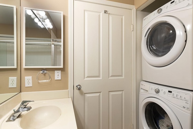 clothes washing area with stacked washer / drying machine and sink