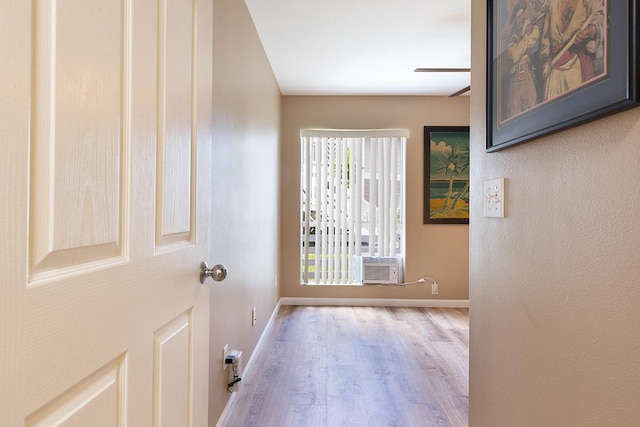 doorway featuring ceiling fan, cooling unit, and light wood-type flooring