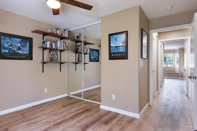 interior space featuring ceiling fan, a closet, and light wood-type flooring