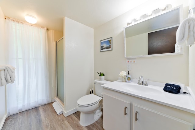 full bath with a stall shower, vanity, toilet, and wood finished floors