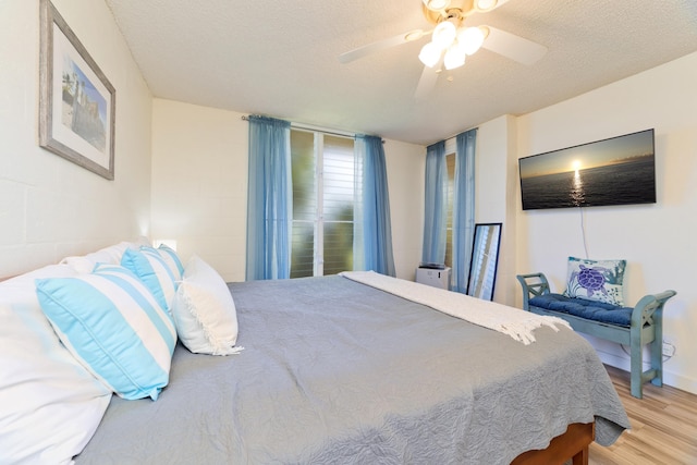 bedroom featuring ceiling fan, a textured ceiling, and wood finished floors