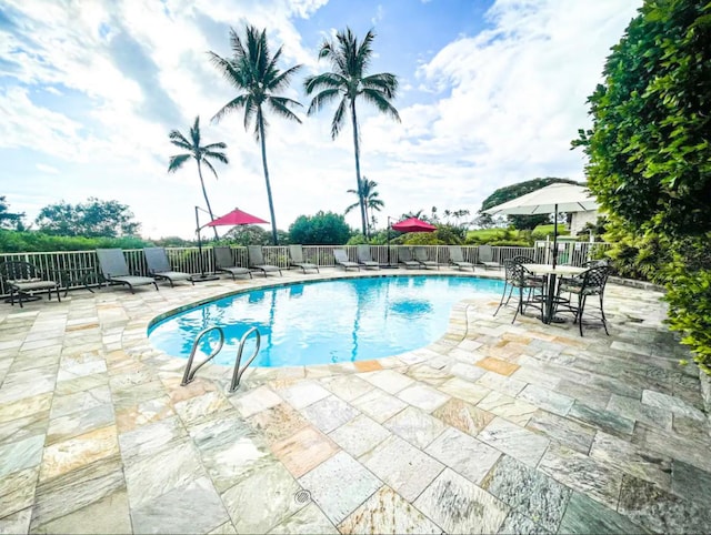 view of swimming pool featuring fence, a fenced in pool, and a patio