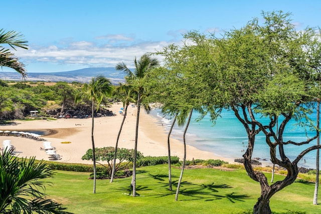 exterior space with a yard, a beach view, and a water view