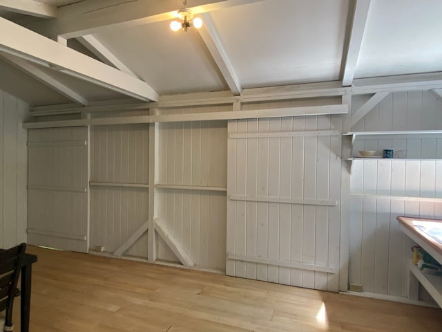 interior space with wood walls, ceiling fan, and light hardwood / wood-style flooring