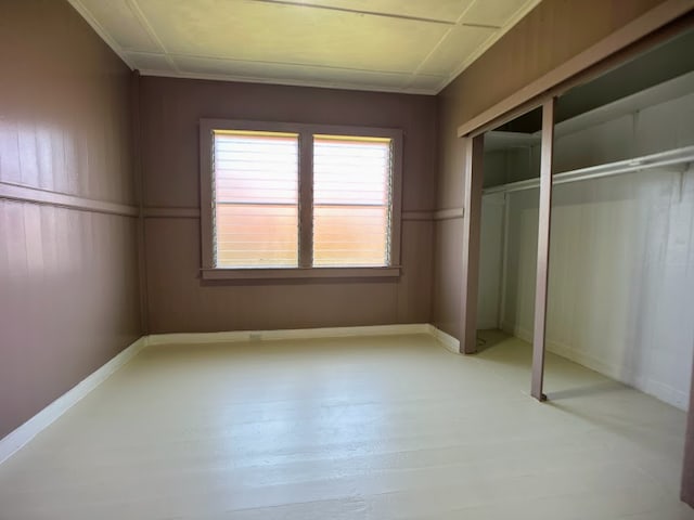 unfurnished bedroom featuring ornamental molding, light hardwood / wood-style floors, and a closet