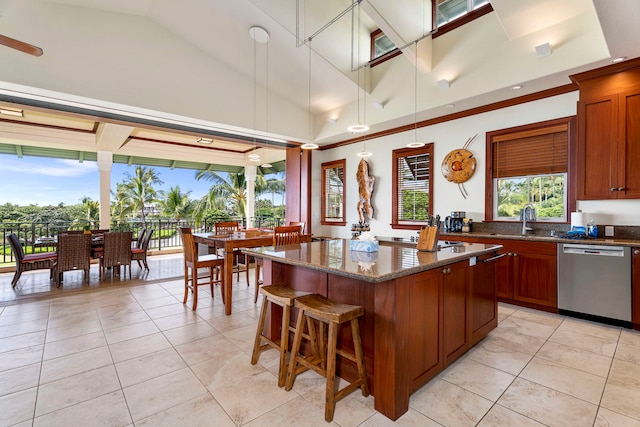 kitchen with dishwasher, a center island, sink, dark stone countertops, and a towering ceiling