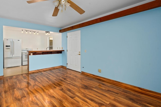 unfurnished living room featuring ceiling fan, dark hardwood / wood-style flooring, and sink