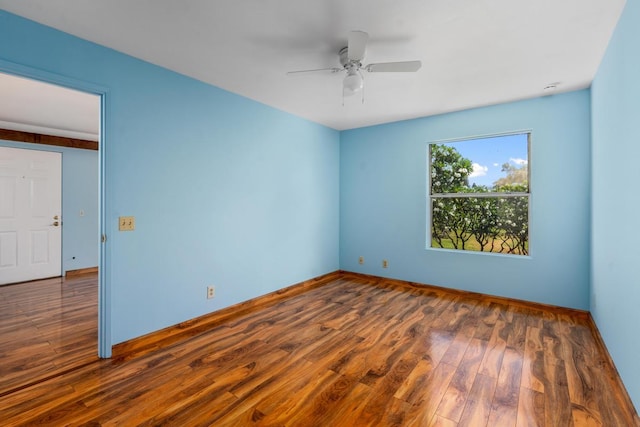 spare room featuring dark wood-type flooring and ceiling fan