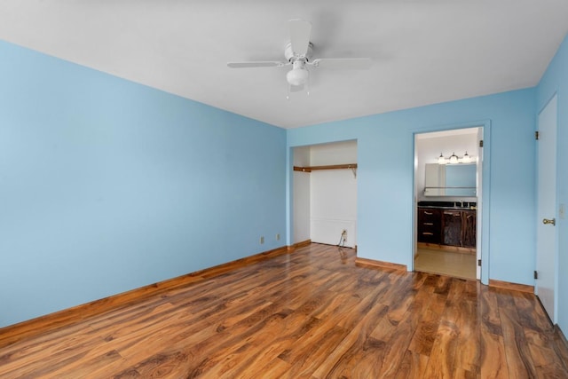 unfurnished bedroom with dark hardwood / wood-style flooring, connected bathroom, and ceiling fan