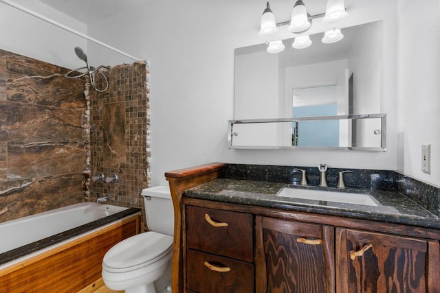 full bathroom with tiled shower / bath, vanity, and toilet